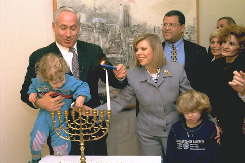Israeli Prime Minister Benjamin Netanyahu lighting Hanuka candles with his wife and sons/Flickr/Government Press Office