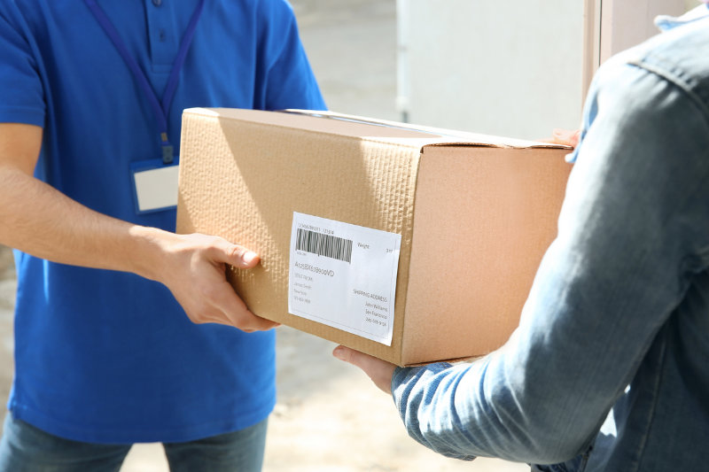 A woman receiving parcel from delivery man