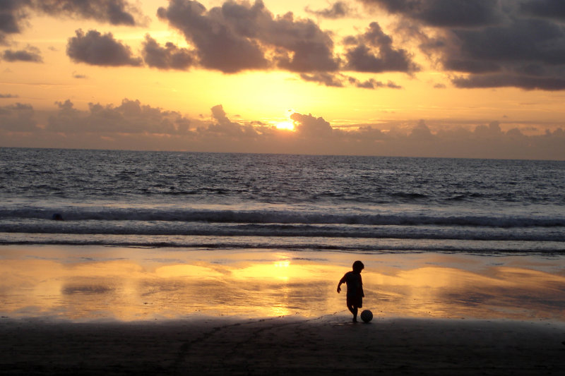Boy on the beach at sunrise